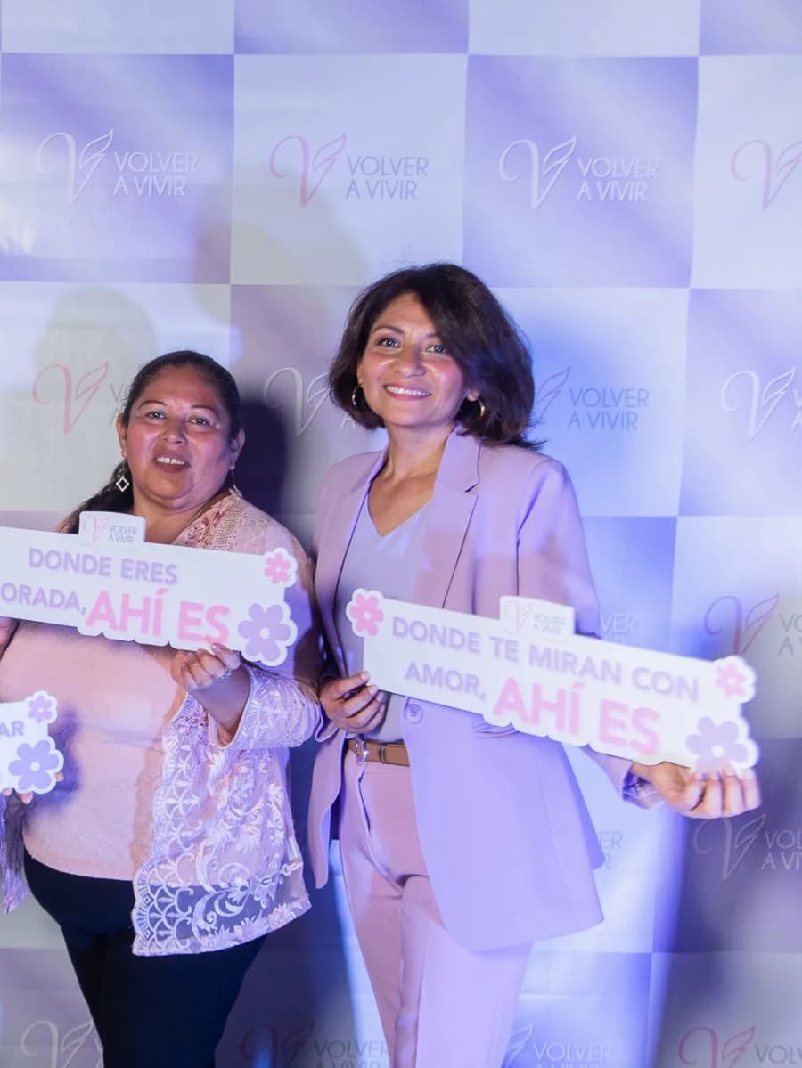 Dos asistentes ante el photocall del aniversario con sus carteles