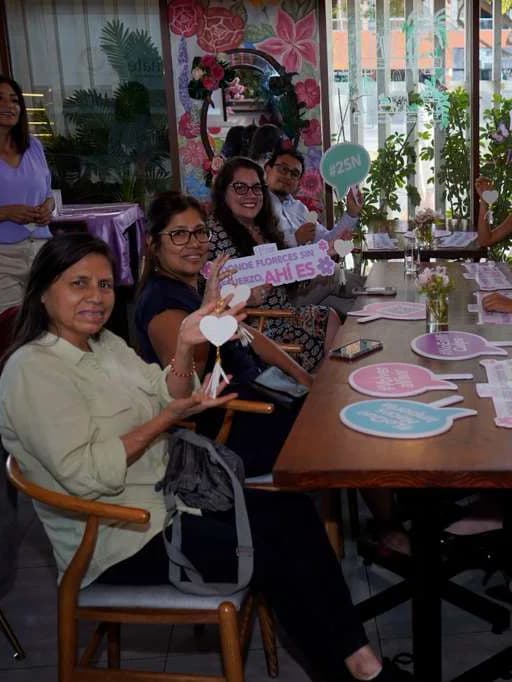Grupo de asistentes al brunch levantando los corazones de la campaña