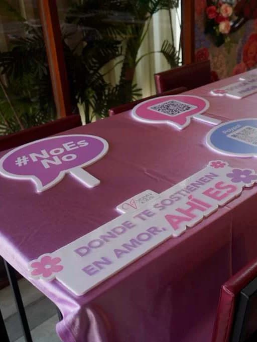 Mesa del brunch con los carteles «#NoEsNo» y «Donde te sostienen en amor, ahí es»