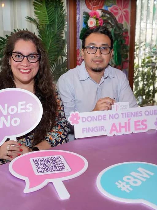 Dos asistentes con los carteles «#NoEsNo» y «Donde no tienes que fingir, ahí es»